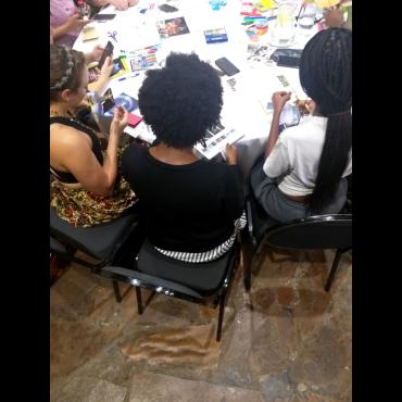 A group of African women making collage art around a table