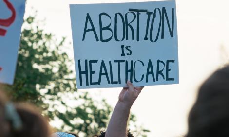 Placard reads, "Abortion is Healthcare". Photo by Gayatri Malhotra on Unsplash