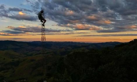 Image description: A lone body on tower against the sunrise and clouds