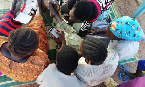 Image description: Overhead photo of a group of people with phone