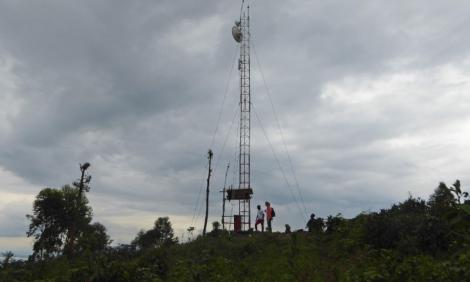 Two people next to one antenna in the mountain