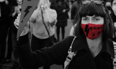 Image description: Woman holding sign