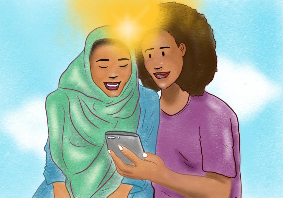 Two african women looking a mobile phone together