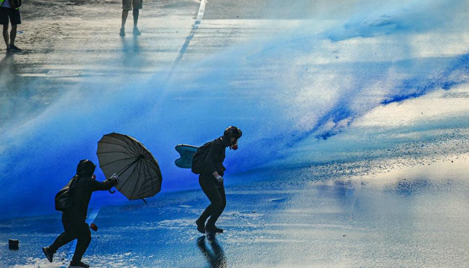 Image description: Water cannons on protestors in HOng Kong