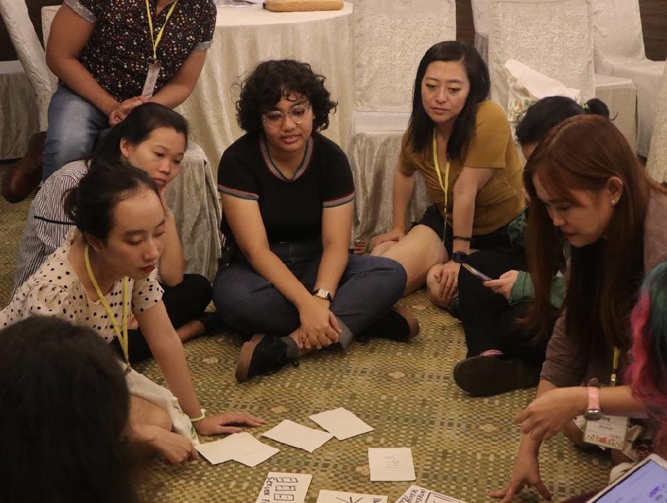 Image description: Women and girls sitting on floor 